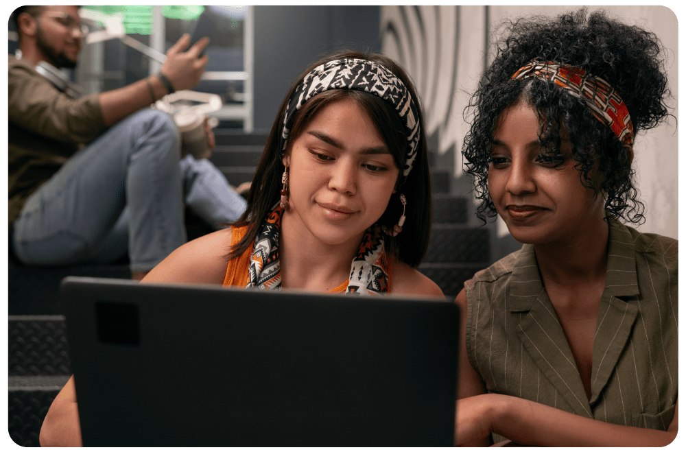Cybersecurity Soft Start Two students collaborating on a laptop, exploring cybersecurity concepts and coding fundamentals as part of an online learning program.