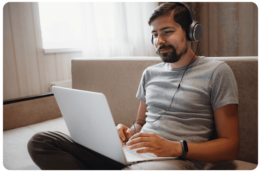 Student wearing headphones and studying on a laptop, engaging in a flexible online cybersecurity training session.